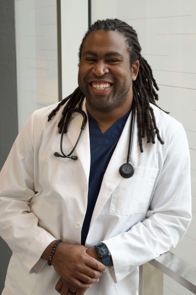 photo of tommie james in a whitecoat and smiling 